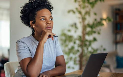 Artigo Perguntas Incomodas_mulher com caneta diante do notebook